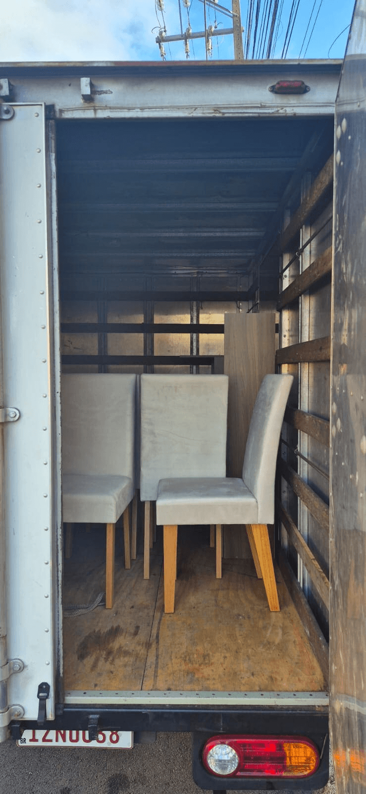Baú do caminhão com cadeiras — frete de móveis em Curitiba